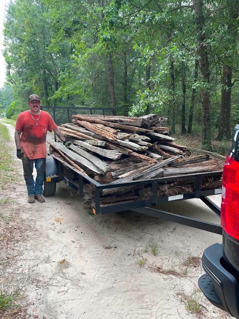 Bull Head Disposal owner standing beside a trailer loaded with wood debris